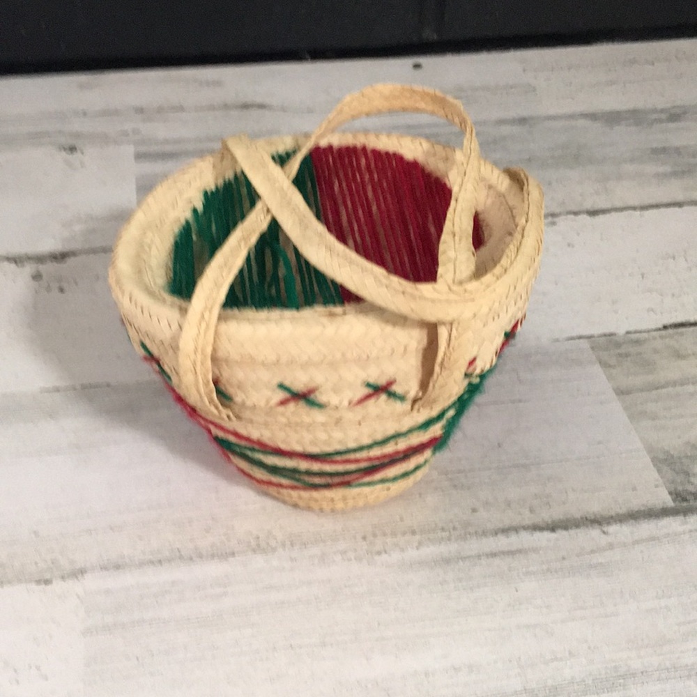 Small basket with handles and lid. Has decorative red & green string designs